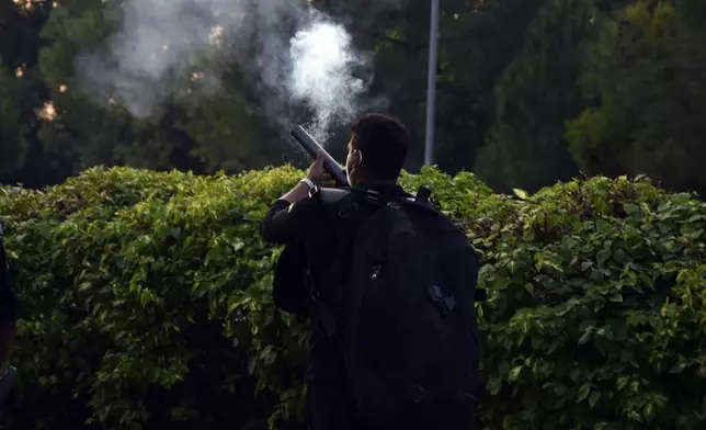 Police officers fire tear gas to disperse the supporters of imprisoned former Prime Minister Imran Khan's party Pakistan Tehreek-e-Insaf during a protest in Islamabad, Pakistan, Friday, Oct. 4, 2024.(AP Photo/W.K. Yousafzai)