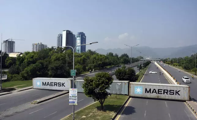 Shipping containers placed by authorities block a key highway to capital city in an attempt to prevent supporters of imprisoned former Prime Minister Imran Khan from holding a rally seeking his release in Islamabad, Pakistan, Friday, Oct. 4, 2024. (AP Photo/W.K. Yousafzai)