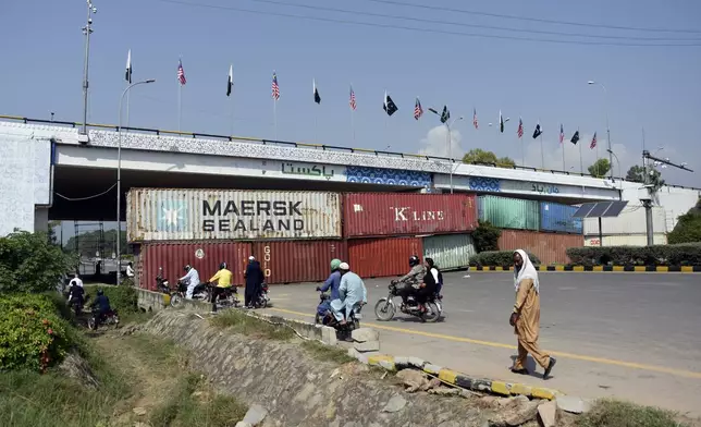 Shipping containers placed by authorities block a key highway to capital city in an attempt to prevent supporters of imprisoned former Prime Minister Imran Khan from holding a rally seeking his release in Islamabad, Pakistan, Friday, Oct. 4, 2024. (AP Photo/W.K. Yousafzai)