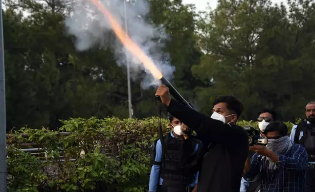 Police officers fire tear gas to disperse the supporters of imprisoned former Prime Minister Imran Khan's party Pakistan Tehreek-e-Insaf during a protest in Islamabad, Pakistan, Friday, Oct. 4, 2024.(AP Photo/W.K. Yousafzai)