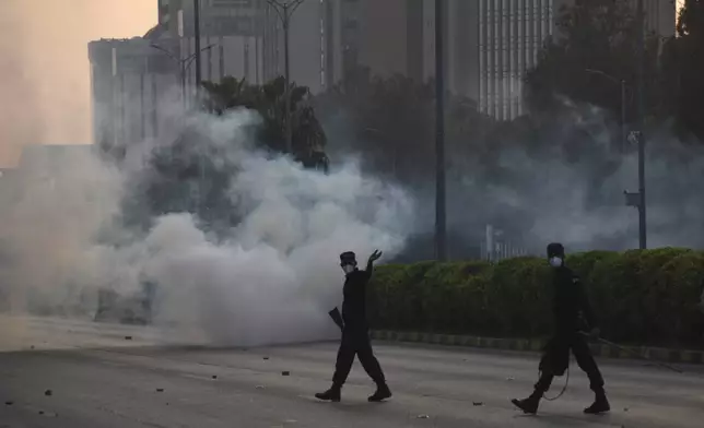 Police officers fire tear gas to disperse the supporters of imprisoned former Prime Minister Imran Khan's party Pakistan Tehreek-e-Insaf during a protest in Islamabad, Pakistan, Friday, Oct. 4, 2024.(AP Photo/W.K. Yousafzai)