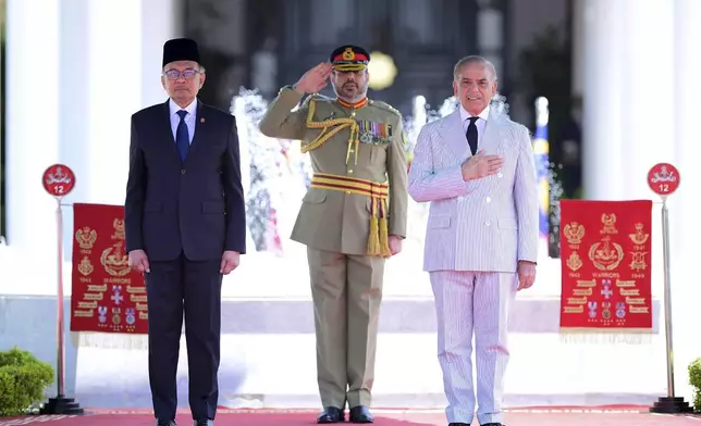 In this photo released by Pakistan's Prime Minister Office, Pakistan's Prime Minister Shehbaz Sharif, right, reviews guard of honor with Malaysian Prime Minister Anwar Ibrahim, at the Prime Minister's House, in Islamabad, Pakistan, Thursday, Oct. 3, 2024. (Prime Minister Office via AP)