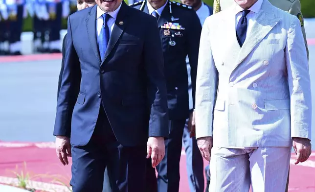 In this photo released by Pakistan's Prime Minister Office, Pakistan's Prime Minister Shehbaz Sharif, right, walks with Malaysian Prime Minister Anwar Ibrahim, at the Prime Minister's House, in Islamabad, Pakistan, Thursday, Oct. 3, 2024. (Prime Minister Office via AP)