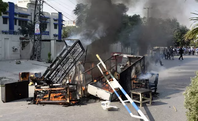 Smoke erupts from burning furniture and other material, set on fire by angry students protesting over an alleged on-campus rape in Punjab, in Rawalpindi, Pakistan, Thursday, Oct. 17, 2024. (AP Photo/W.K. Yousafzai)