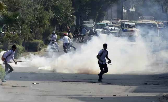 Police fire tear gas to disperse students protesting over an alleged on-campus rape in Punjab, in Rawalpindi, Pakistan, Thursday, Oct. 17, 2024. (AP Photo/W.K. Yousafzai)