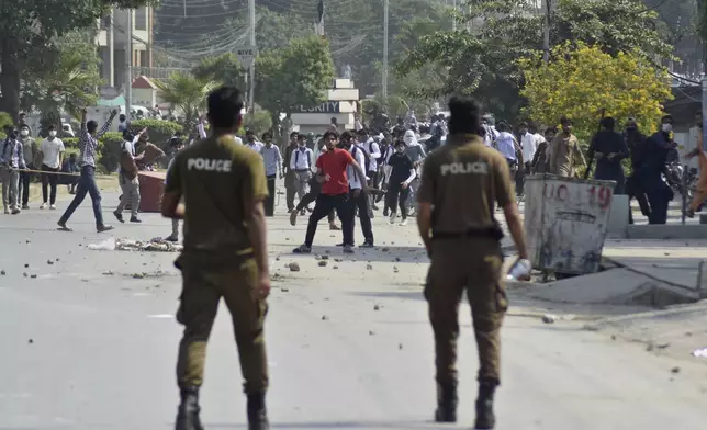 Students throw stones toward police during clashes as they protest over an alleged on-campus rape in Punjab, in Rawalpindi, Pakistan, Thursday, Oct. 17, 2024. (AP Photo/W.K. Yousafzai)