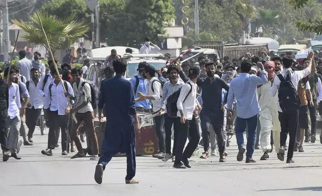 Students throw stones toward police during clashes as they protest over an alleged on-campus rape in Punjab, in Rawalpindi, Pakistan, Thursday, Oct. 17, 2024. (AP Photo/W.K. Yousafzai)