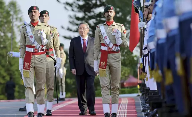 In this photo released by the Press Information Department, visiting China's Premier Li Qiang reviews the guard of honor during a welcome ceremony, in Islamabad, Pakistan, Monday, Oct. 14, 2024. (Press Information Department via AP)