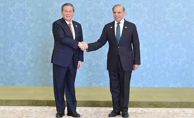 In this photo released by the Press Information Department, China's Premier Li Qiang, left, shakes hand with his Pakistani counterpart Shehbaz Sharif as he arrives to attend Shanghai Cooperation Organization (SCO) meeting, in Islamabad, Pakistan, Wednesday, Oct. 16, 2024. (Press Information Department via AP)