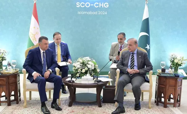 In this photo released by the Press Information Department, Tajikistan's Prime Minister Qohir Rasulzoda, front left, listens to his Pakistani counterpart Shehbad Sharif ahead of an Asian security group meeting in Islamabad, Pakistan, Tuesday, Oct. 15, 2024. (Press Information Department via AP)