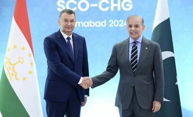 In this photo released by the Press Information Department, Tajikistan's Prime Minister Qohir Rasulzoda, left, shakes hand with his Pakistani counterpart Shehbad Sharif prior to an an Asian security group meeting, in Islamabad, Pakistan, Tuesday, Oct. 15, 2024. (Press Information Department via AP)