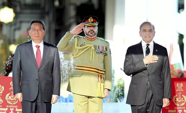 In this photo released by the Press Information Department, visiting China's Premier Li Qiang, left, and Pakistan's Prime Minister Shehbaz Sharif attend a attends a welcome ceremony, in Islamabad, Pakistan, Monday, Oct. 14, 2024. (Press Information Department via AP)