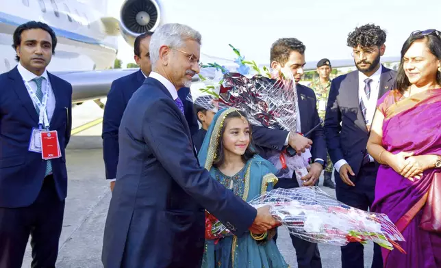 In this photo released by the Press Information Department, India's Minister for External Affairs Subrahmanyam Jaishankar receives a flower bouquet from a girl upon his arrival at an airbase in Rawalpindi, Pakistan, Tuesday, Oct. 15, 2024, ahead of an Asian security group meeting. (Press Information Department via AP)