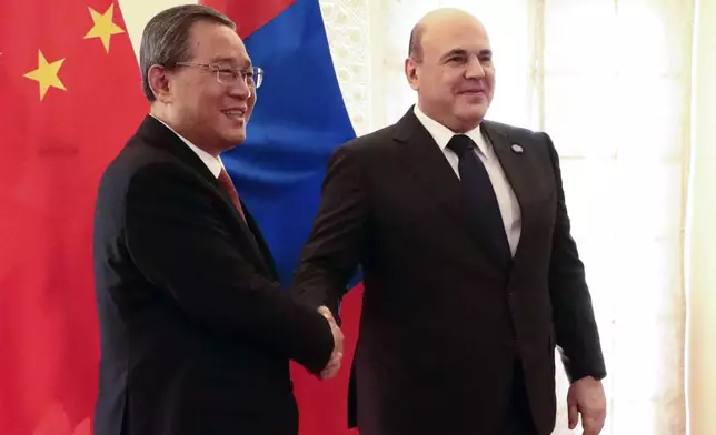 Chinese Premier Li Qiang, left, and Russian Prime Minister Mikhail Mishustin pose for a photo on the sidelines of the Shanghai Cooperation Organization (SCO) Council of Heads of Governments Summit in Islamabad, Pakistan, Wednesday, Oct. 16, 2024. (Alexander Miridonov, Sputnik, Government Pool Photo via AP)