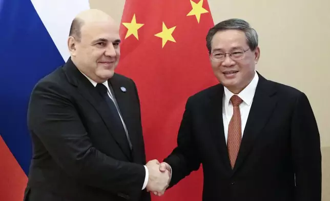 Chinese Premier Li Qiang, right, and Russian Prime Minister Mikhail Mishustin pose for a photo on the sidelines of the Shanghai Cooperation Organization (SCO) Council of Heads of Governments Summit in Islamabad, Pakistan, Wednesday, Oct. 16, 2024. (Roman Naumov, Sputnik, Government Pool Photo via AP)