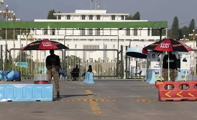 Paramilitary soldiers stand guard at a barricaded road leading to Presidency, in background, and to the venue of the upcoming Shanghai Cooperation Organization (SCO) summit in Islamabad, Pakistan, Sunday, Oct. 13, 2024. (AP Photo/Anjum Naveed)