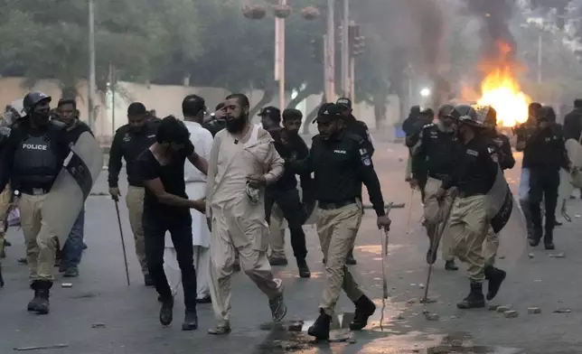 Police detain a supporter of the Tehreek-e-Labbaik Pakistan party during clashes in Karachi, Pakistan, Sunday, Oct. 13, 2024. (AP Photo/Fareed Khan)