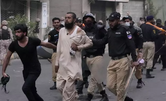 Police detain a supporter of the Tehreek-e-Labbaik Pakistan party during clashes in Karachi, Pakistan, Sunday, Oct. 13, 2024. (AP Photo/Fareed Khan)