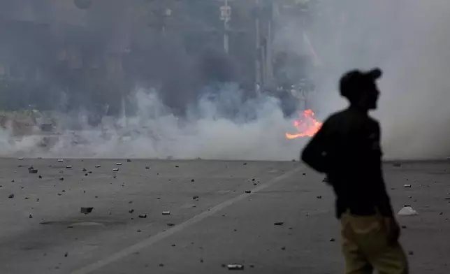 Police fire tear gas shell to disperse supporters of the Tehreek-e-Labbaik Pakistan party during clashes in Karachi, Pakistan, Sunday, Oct. 13, 2024. (AP Photo/Fareed Khan)