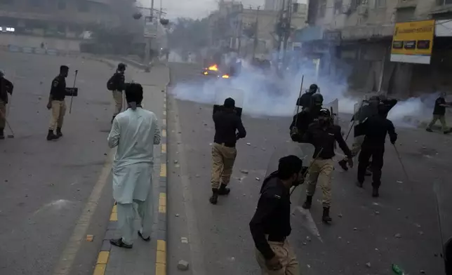 Police fire tear gas shell to disperse supporters of the Tehreek-e-Labbaik Pakistan party during clashes in Karachi, Pakistan, Sunday, Oct. 13, 2024. (AP Photo/Fareed Khan)