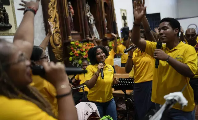 Pilgrims sing and dance inside San Felipe Church to honor the Black Christ in Portobelo, Panama, Monday, Oct. 21, 2024, during a festival celebrating the iconic statue that was found on the shore in 1658. (AP Photo/Matias Delacroix)