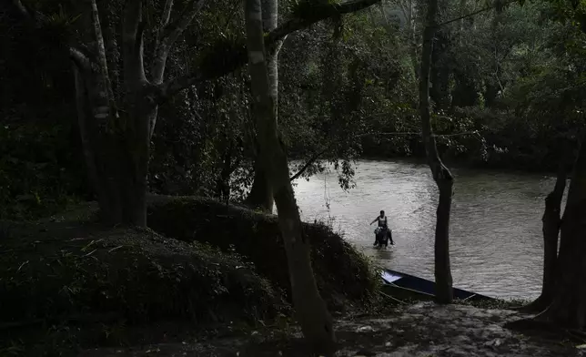 A woman rides her horse in the Indio River, which could have its flow reduced and submerge her community of Limon under a proposed plan to secure the Panama Canal’s uninterrupted operation, in Panama, Saturday, Aug. 31, 2024. (AP Photo/Matias Delacroix)