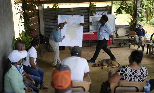 Panama Canal representatives explain to locals how a proposed dam project in the Indio River that aims to secure the canal's uninterrupted operation could affect the future of El Jobo, Panama, Saturday, Aug. 31, 2024. (AP Photo/Matias Delacroix)