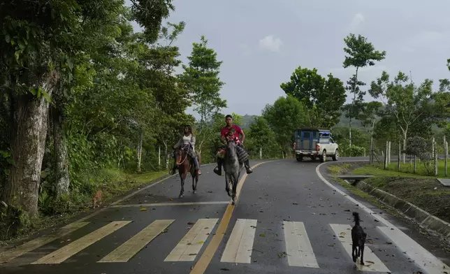 Locals ride horses in the village of Limon, which would be submerged in a proposed plan to dam the nearby Indio River to secure the Panama Canal’s uninterrupted operation, in Panama, Saturday, Aug. 31, 2024. (AP Photo/Matias Delacroix)