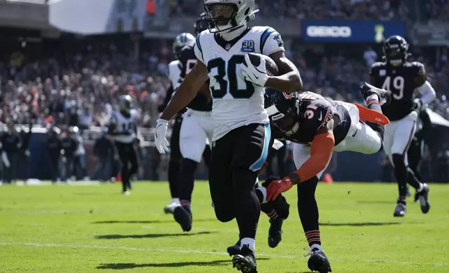 Carolina Panthers running back Chuba Hubbard (30) scores on a 38-yard touchdown run as Chicago Bears safety Kevin Byard III (31) defends during the first half of an NFL football game Sunday, Oct. 6, 2024, in Chicago. (AP Photo/Nam Y. Huh)