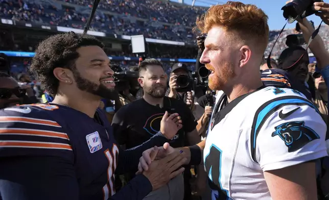 Chicago Bears quarterback Caleb Williams, left, and Carolina Panthers quarterback Andy Dalton, right, talk after an NFL football game Sunday, Oct. 6, 2024, in Chicago. (AP Photo/Charles Rex Arbogast)