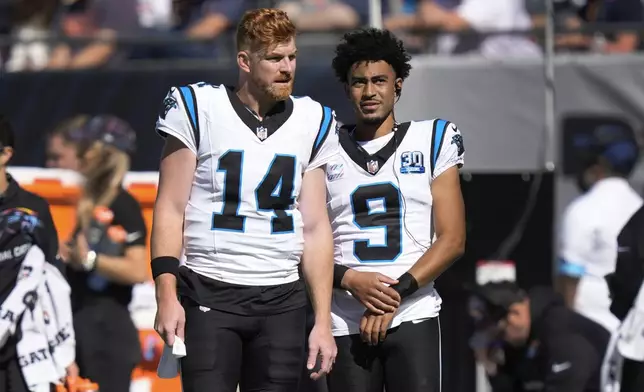 Carolina Panthers quarterbacks Andy Dalton (14) and Bryce Young (9) watches against the Chicago Bears during the first half of an NFL football game Sunday, Oct. 6, 2024, in Chicago. (AP Photo/Charles Rex Arbogast)