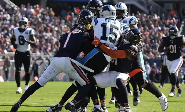 Carolina Panthers wide receiver Jonathan Mingo (15) is brought down by ;Chicago Bears cornerback Jaylon Johnson (1) and safety Kevin Byard III (31) during the second half of an NFL football game Sunday, Oct. 6, 2024, in Chicago. (AP Photo/Nam Y. Huh)