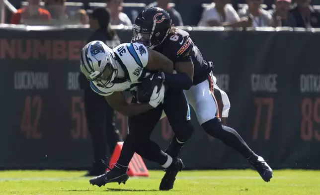 Carolina Panthers running back Chuba Hubbard (30) is tackled by Chicago Bears cornerback Kyler Gordon (6) during the first half of an NFL football game Sunday, Oct. 6, 2024, in Chicago. (AP Photo/Nam Y. Huh)