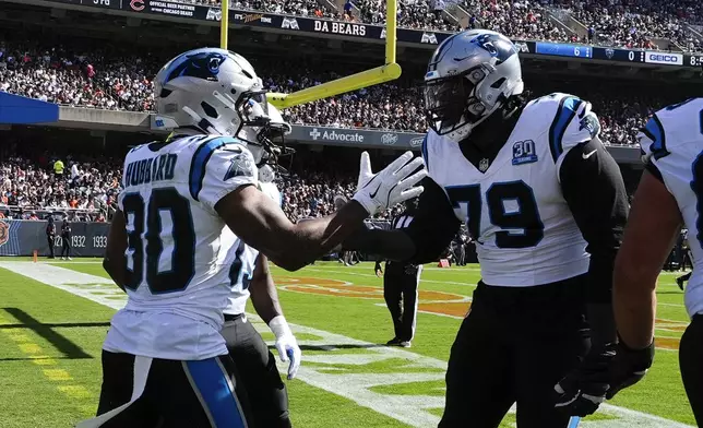 Carolina Panthers running back Chuba Hubbard (30) celebrates his 38-yard touchdown run with Ikem Ekwonu (79) during the first half of an NFL football game against the Chicago Bears Sunday, Oct. 6, 2024, in Chicago. (AP Photo/Nam Y. Huh)