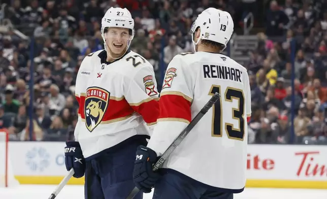 Florida Panthers' Eetu Luostarinen, left, celebrates his goal against the Columbus Blue Jackets with teammate Sam Reinhart during the third period of an NHL hockey game Tuesday, Oct. 15, 2024, in Columbus, Ohio. (AP Photo/Jay LaPrete)