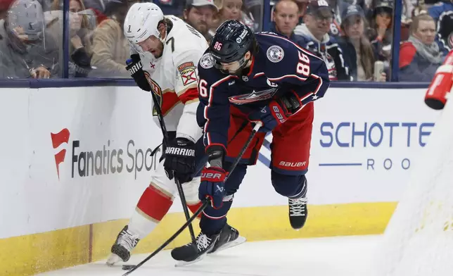 Florida Panthers' Dmitry Kulikov, left, and Columbus Blue Jackets' Kirill Marchenko fight for the puck during the second period of an NHL hockey game Tuesday, Oct. 15, 2024, in Columbus, Ohio. (AP Photo/Jay LaPrete)