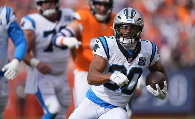 Carolina Panthers running back Chuba Hubbard (30) runs the ball after a catch during the first half of an NFL football game against the Denver Broncos, Sunday, Oct. 27, 2024, in Denver. (AP Photo/David Zalubowski)