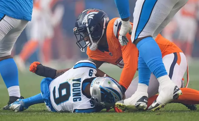 Denver Broncos linebacker Nik Bonitto, top, sacks Carolina Panthers quarterback Bryce Young (9) during the second half of an NFL football game Sunday, Oct. 27, 2024, in Denver. (AP Photo/David Zalubowski)