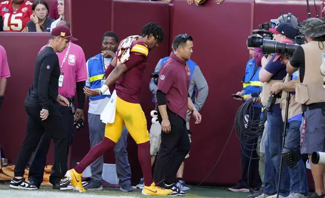 Washington Commanders quarterback Jayden Daniels walks off the field after getting injured during the first half of an NFL football game against the Carolina Panthers, Sunday, Oct. 20, 2024, in Landover, Md. (AP Photo/Stephanie Scarbrough)