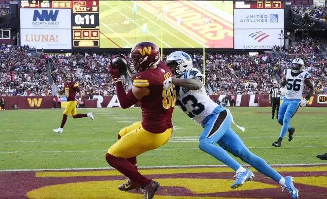 Washington Commanders tight end Zach Ertz (86) catches a 12-yard touchdown pass in front of Carolina Panthers cornerback Dane Jackson (23) during the first half of an NFL football game, Sunday, Oct. 20, 2024, in Landover, Md. (AP Photo/Nick Wass)