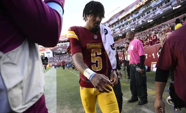 Washington Commanders quarterback Jayden Daniels walks off the field after getting injured during the first half of an NFL football game against the Carolina Panthers, Sunday, Oct. 20, 2024, in Landover, Md. (AP Photo/Nick Wass)