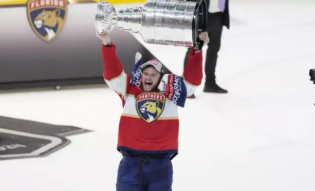 FILE - Florida Panthers center Aleksander Barkov (16) lifts the Stanley Cup trophy after Game 7 of the NHL hockey Stanley Cup Final, on June 24, 2024, in Sunrise, Fla. (AP Photo/Rebecca Blackwell, File)