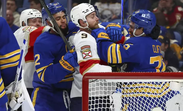 Buffalo Sabres left wing Jordan Greenway (12) and defenseman Connor Clifton (75) tie up Florida Panthers center Sam Bennett (9) behind the net during the second period of an NHL hockey game Monday, Oct. 28, 2024, in Buffalo, N.Y. (AP Photo/Jeffrey T. Barnes)