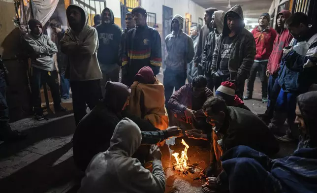 Prisoners warm themselves by a fire inside their pavilion at the Juan de la Vega prison in Emboscada, Paraguay, Friday, July 12, 2024. (AP Photo/Rodrigo Abd)