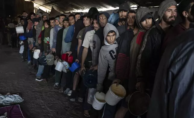 Prisoners line up for a jail-provided meal known as "vori-vori" at the Tacumbu prison in Asuncion, Paraguay, Wednesday, July 10, 2024. The soup, made of chicken or beef, vegetables, and corn balls stuffed with cheese, is considered the food of the poorest inmates, and those who can afford it prefer to buy other food. (AP Photo/Rodrigo Abd)