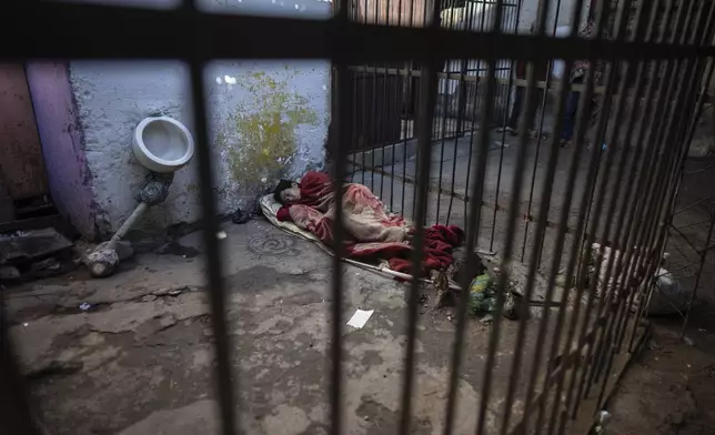 A prisoner rests in an external corridor of the Tacumbu prison in Asuncion, Paraguay, Sunday, July 8, 2024. (AP Photo/Rodrigo Abd)