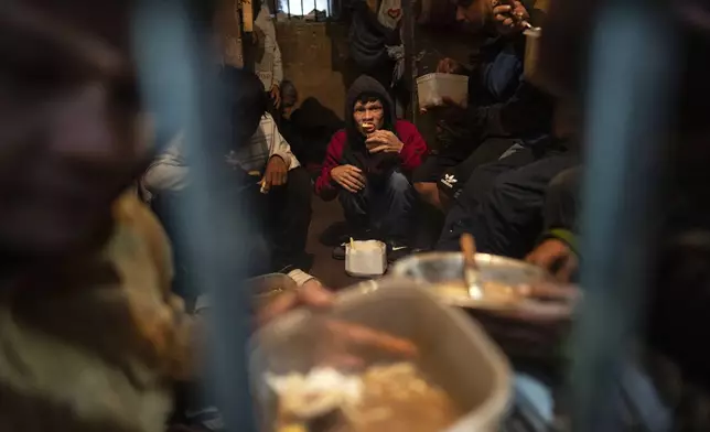 Prisoners eat dinner in their cell at the Juan de la Vega prison in Emboscada, Paraguay, Friday, July 12, 2024. (AP Photo/Rodrigo Abd)