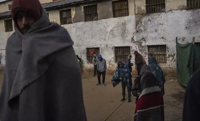 Prisoners keep warm with blankets in the courtyard of the Tacumbu prison in Asuncion, Paraguay, Monday, July 9, 2024. Prisoners are allowed to be outside of their cellblocks until 4pm. (AP Photo/Rodrigo Abd)