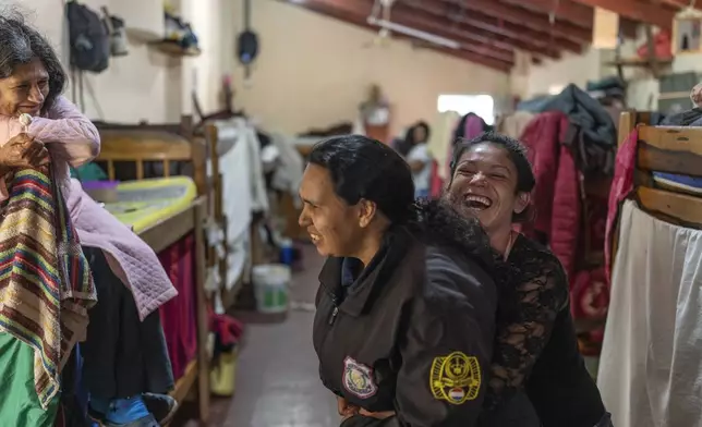 A prisoner, right, playfully hugs a female prison guard at the women's pavilion of the Regional Penitentiary in Villarica, Paraguay, Sunday, Sept. 1, 2024. (AP Photo/Rodrigo Abd)