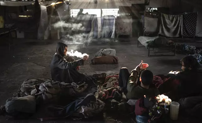 Prisoners smoke crack inside the Tacumbu prison in Asuncion, Paraguay, Sunday, July 8, 2024. Drugs are not allowed but some manage to smuggle them into the jail. (AP Photo/Rodrigo Abd)